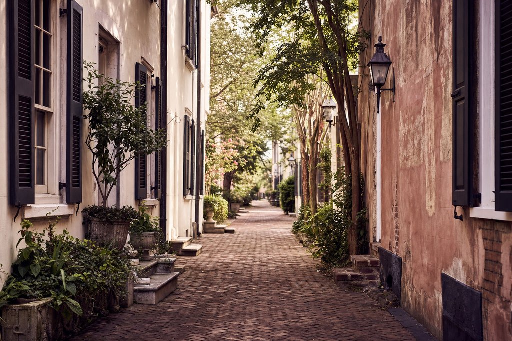 a brick footway between two colonial house fronts with shuttered windows. (AI-generated image)