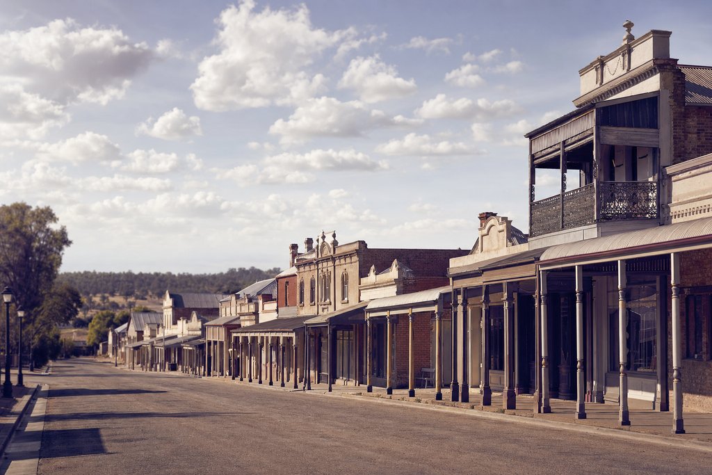 A wide country main street of nineteenth-century verandahed shopfronts under a big sky, regional Victoria. (AI-generated image)